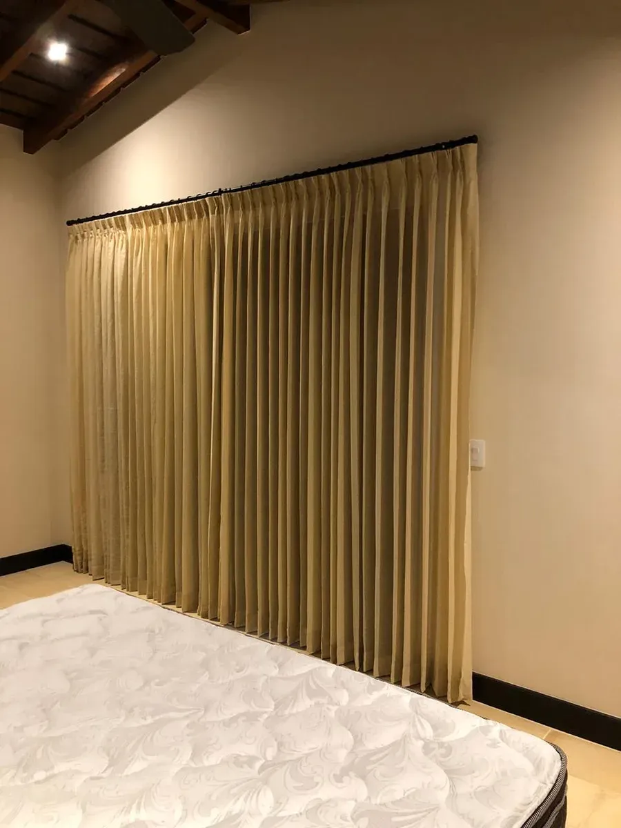 Cortinas de tela en ventana con vista al jardín.