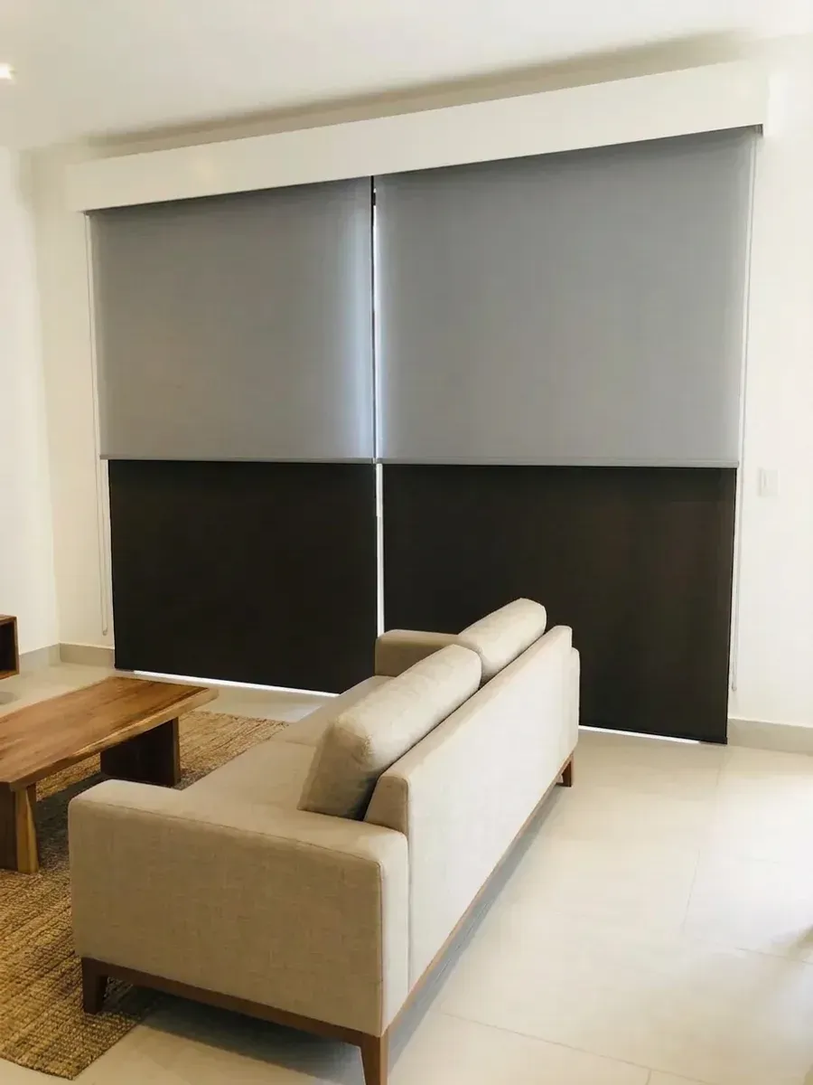 Estar con el sistema Día y Noche cubriendo el ventanal de pared a pared en dos paños, sofá de lino y mesa de centro de madera.