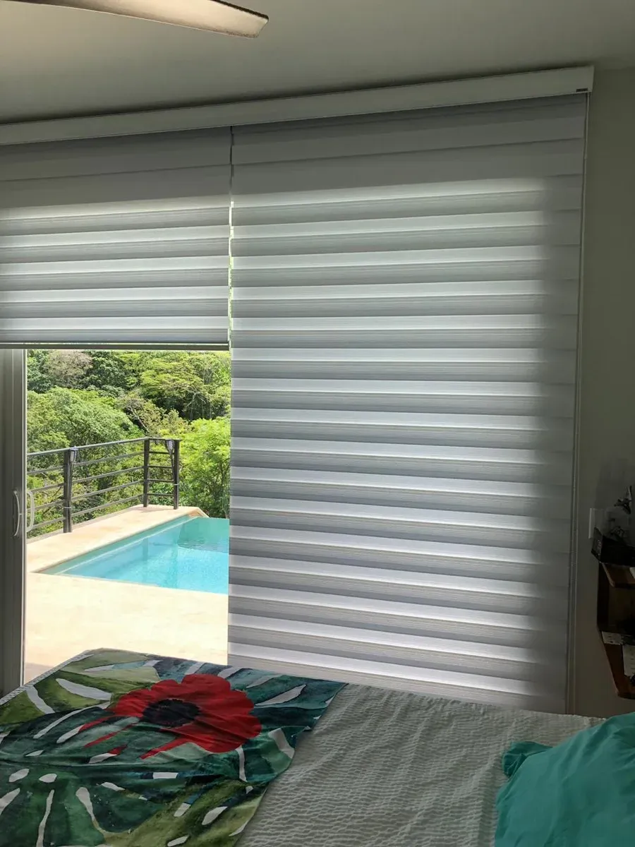 Double Roller en ventana de dormitorio con luz filtrada.