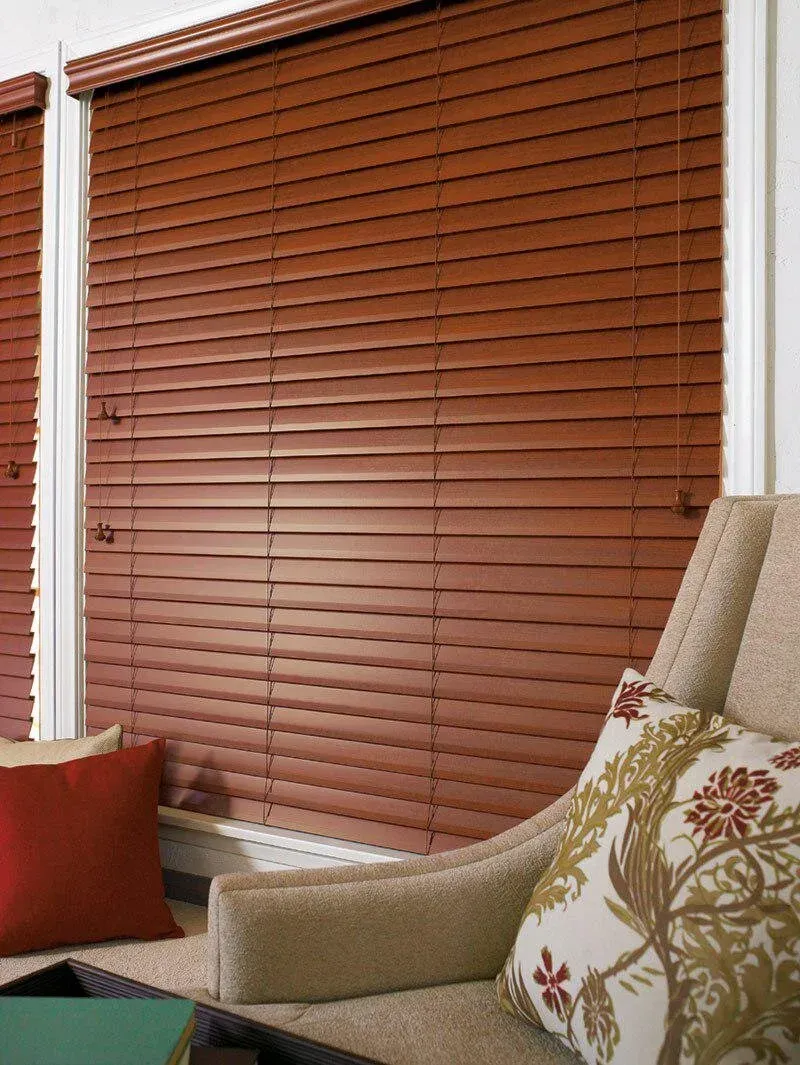 Persiana de madera en ventana de dormitorio con luz de tarde.