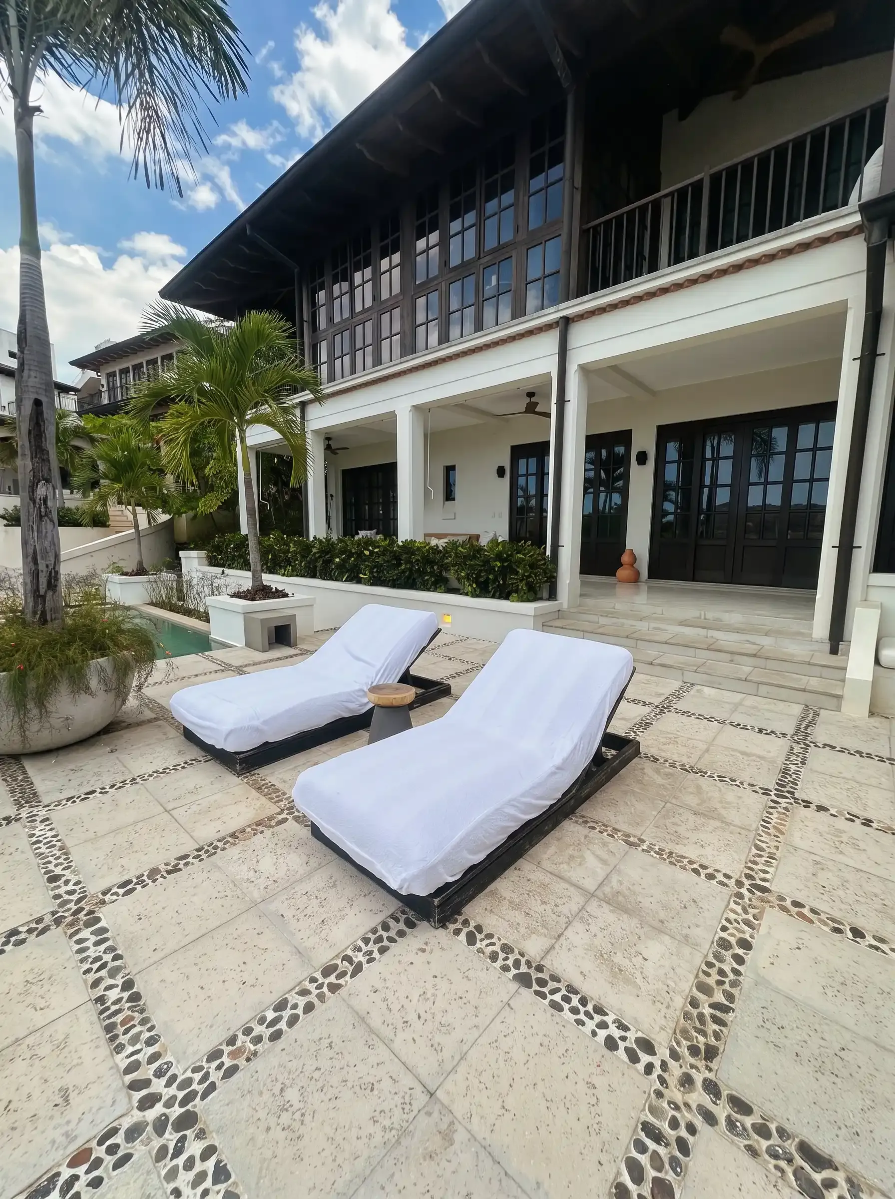 Fachada con tumbonas y mosaico geométrico · Liberia