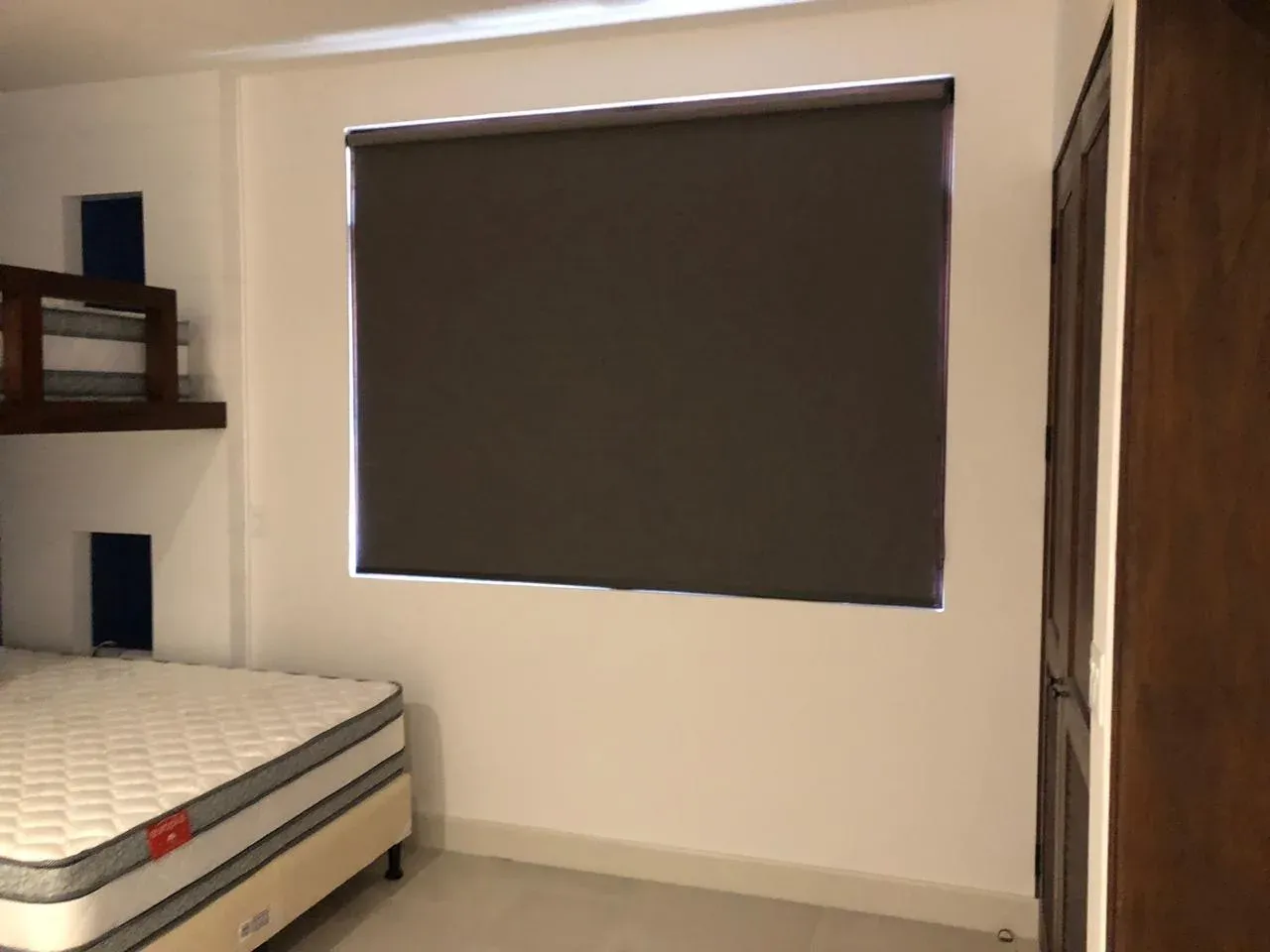 Detalle de tejido blackout en sala con vista al jardín.