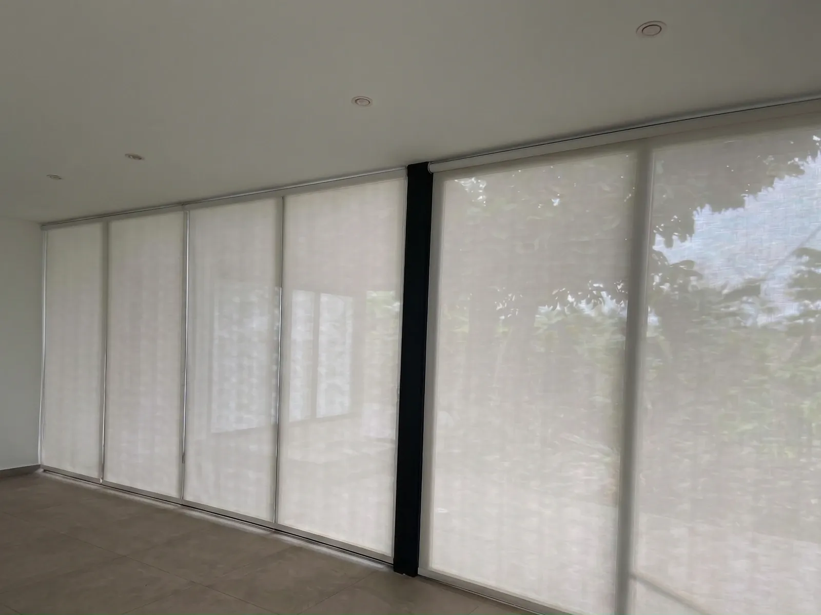 Cortinas Roller Blackout instaladas en los ventanales de una sala, con luz natural.