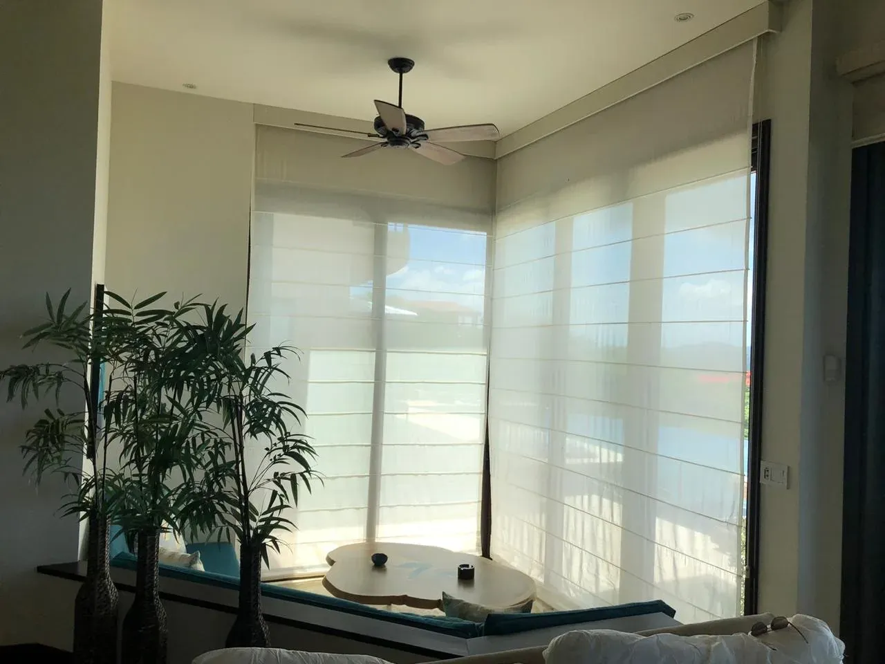 Cortinas romanas de tela en habitación con luz suave.